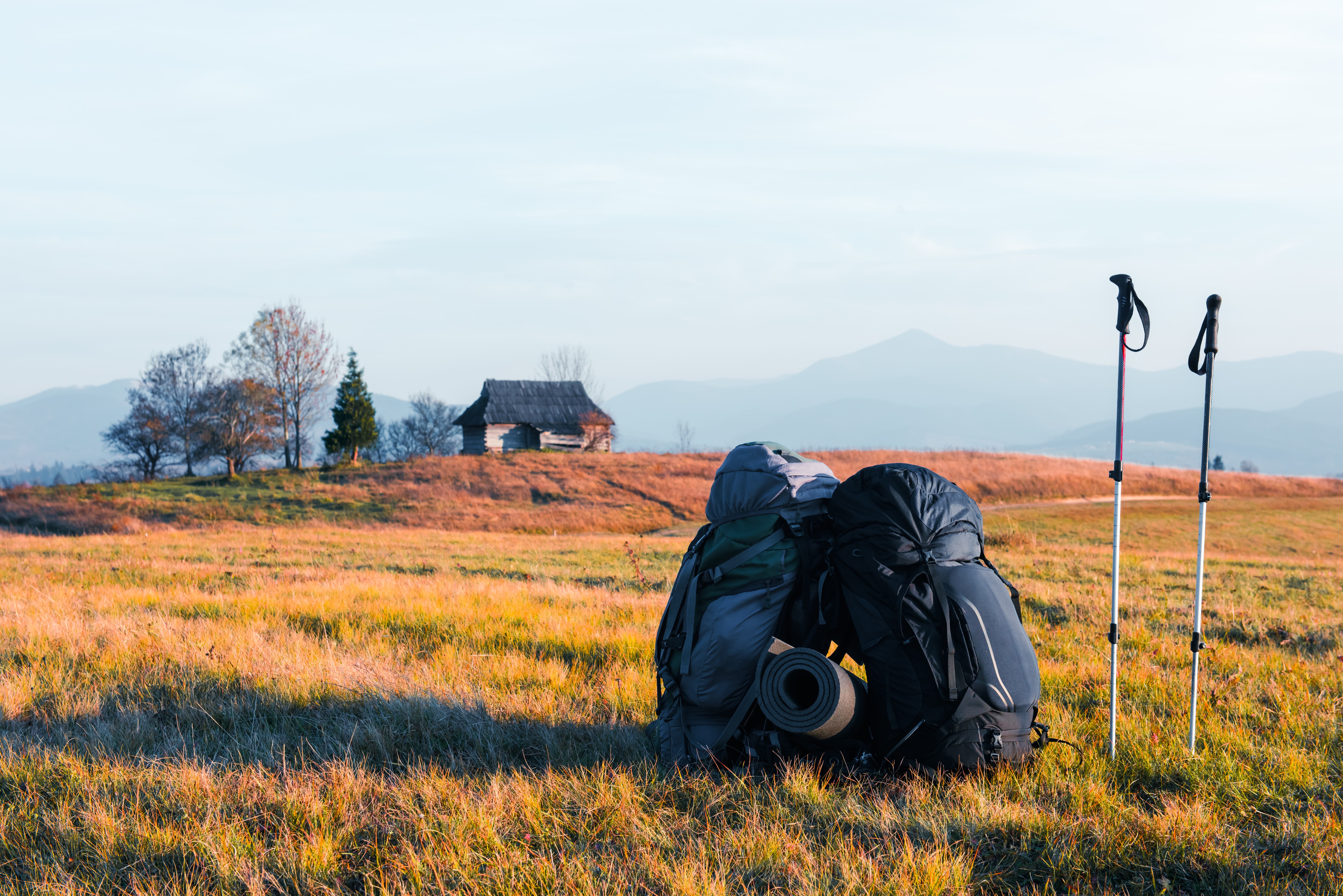 Autumn Camping Magic: Swiss Camping Equipment, deux sacs à dos dans la vallée des montagnes YF7PC6J - Swiss Made Direct - camping suisse, équipement de camping suisse, camping d'automne, couverture militaire suisse, équipement de camping